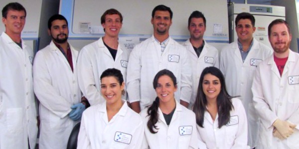 10 students pose in lab coats